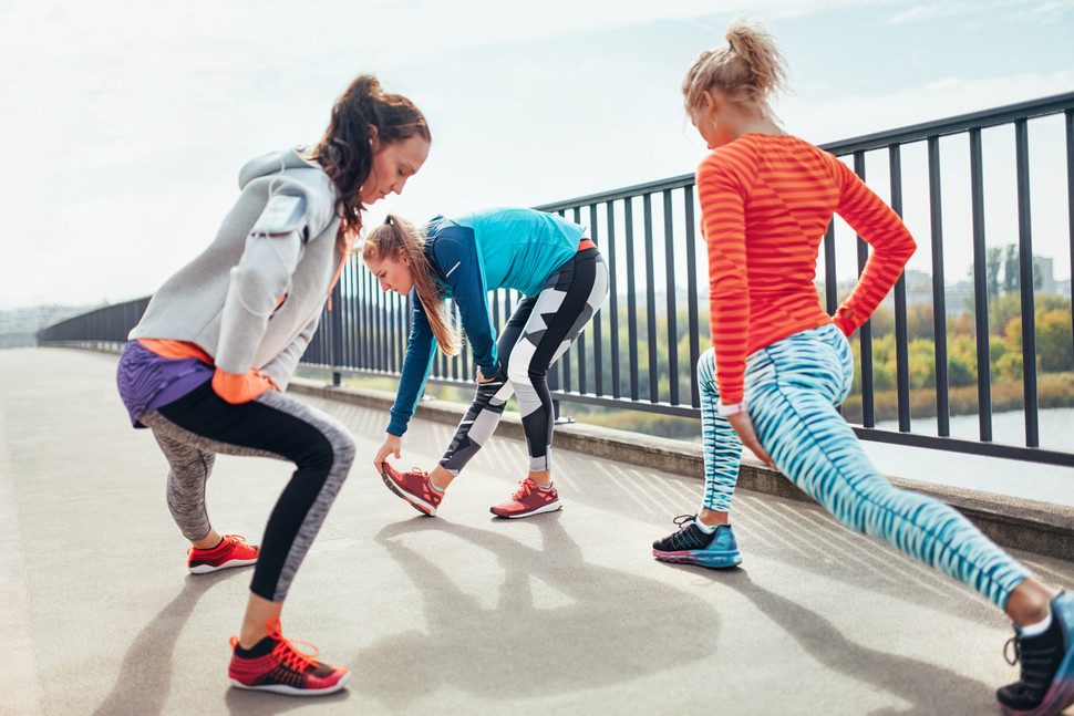 polar running program maraton three female runners doing warm up exercise on footbridge 970x647 c