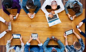 personas en una mesa con sus dispositivos