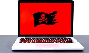 laptop con la pantalla roja y una bandera negra en el medio con una calavera