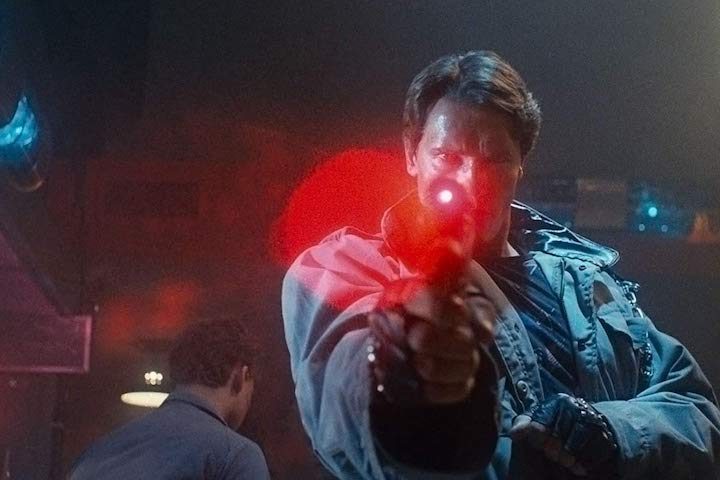 Arnold Schwarzenegger apunta con un arma con mira láser en "Terminator" (1984).