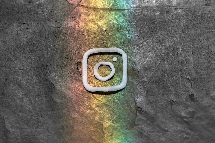 Logo de instagram dibujado sobre un fondo que se asemeja a un muro de piedra. Te explicamos cómo publicar GIF en Instagram