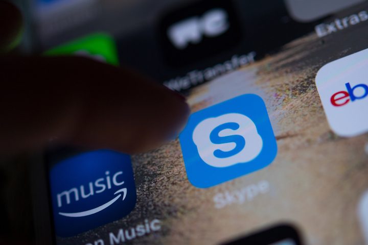 Una persona apunta el ícono de Skype en la pantalla de su teléfono móvil | Conoce cómo grabar llamadas en Skype