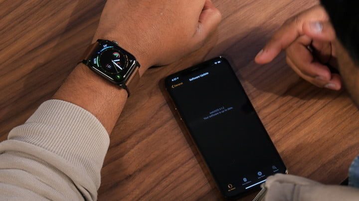Una persona revisa la función de electrocardioagrama en su teléfono móvil y en su celular.