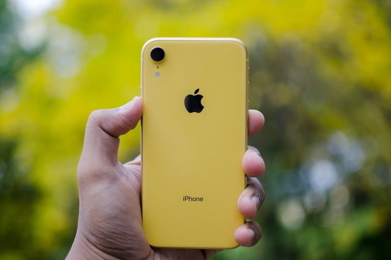 Un iPhone XR sostenido por una persona al aire libre.