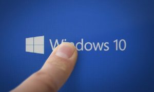 Una persona apunta con su dedo el logo de Windows 10