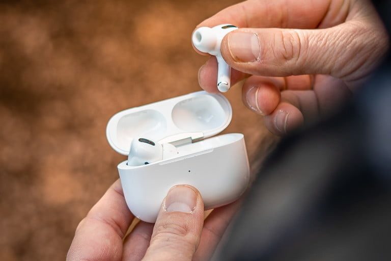 Una persona guarda en el caja de carga inalámbrica los AirPods Pro, los mejores audífonos inalámbricos para iPhone