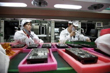 Trabajadores de una industria china en proceso de ensamblaje
