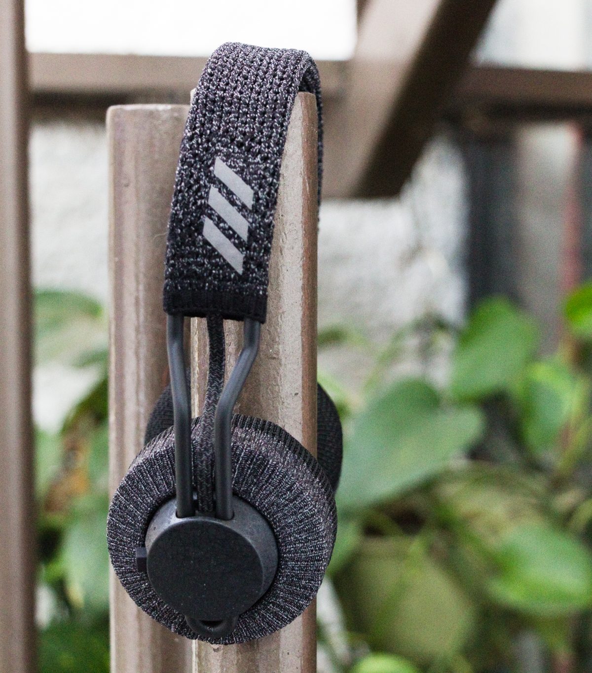 UsuarAudífonos inalámbricos Adidas RPT-01 sobre un tubo