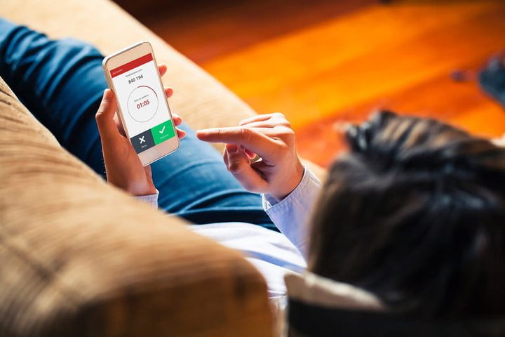 Usuario empleando celular mientras descansa