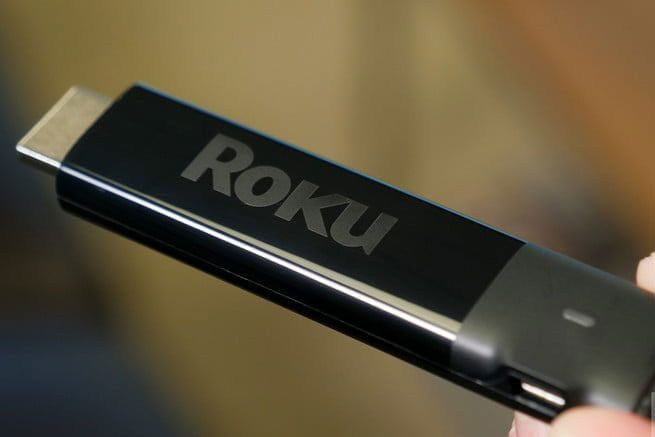 Una persona sostiene con sus dedos el Roku Stick, uno de los mejores productos electrónicos por menos de $100 dólares