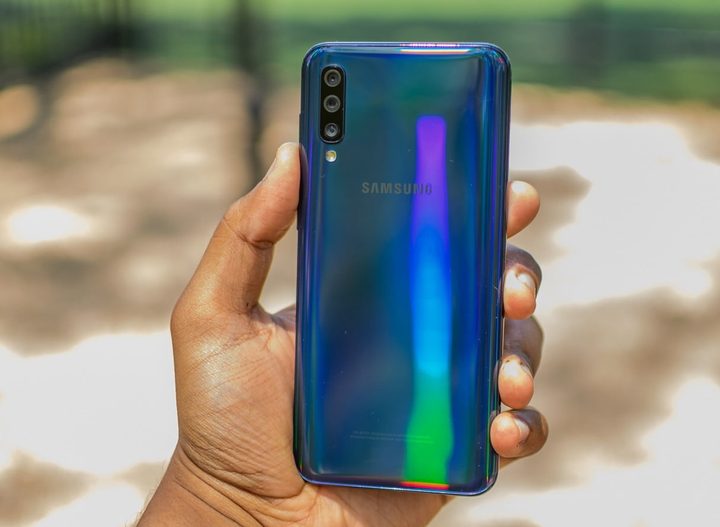Una persona sostiene en sus manos el Galaxy A50 de Samsung, uno de los los mejores teléfonos baratos del mercado.