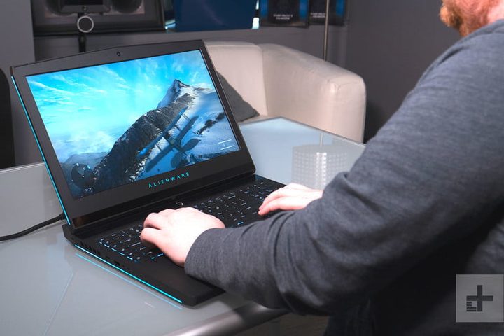 Hombre usando portatil Alienware y se muestra en pantalla una montaña
