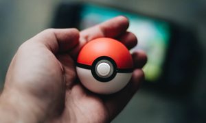 Una persona sostiene una pokebola con su mano. Te contamos cómo intercambiar en Pokémon Go con tus amigos.