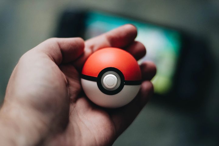 Una persona sostiene una pokebola con su mano. Te contamos cómo intercambiar en Pokémon Go con tus amigos.