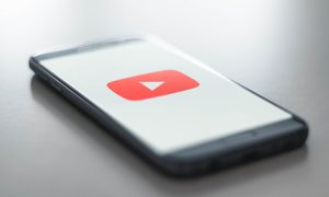 Un celular con el logo de Youtube. Te contamos cómo descargar videos de Youtube.