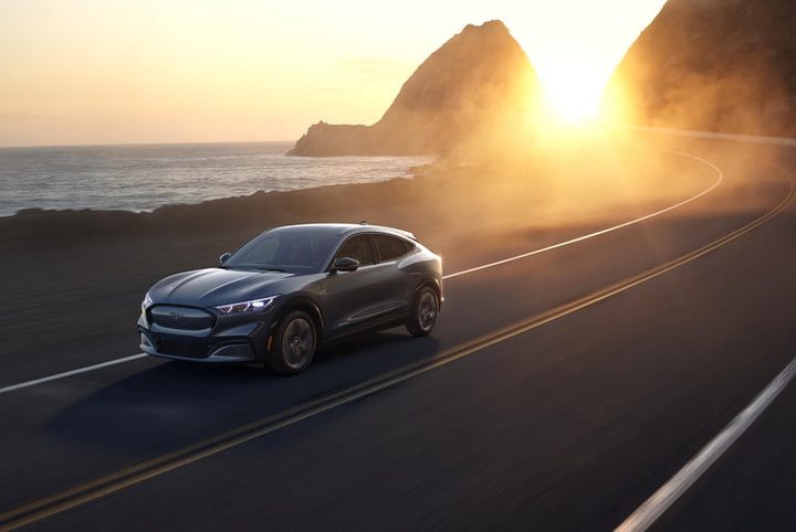un auto en la carretera con el atardecer