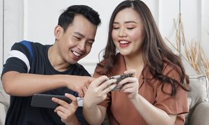 joven pareja jugando con sus teléfonos