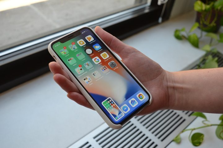 mano agarrando un cómo tomar captura de pantalla un iPhone X