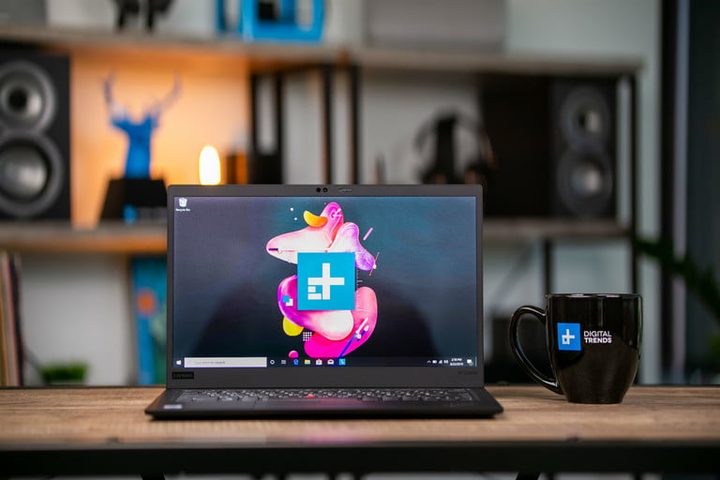 Lenovo ThinkPad X1 Carbon sobre una mesa ostrando pantalla y una taza negra a un lado