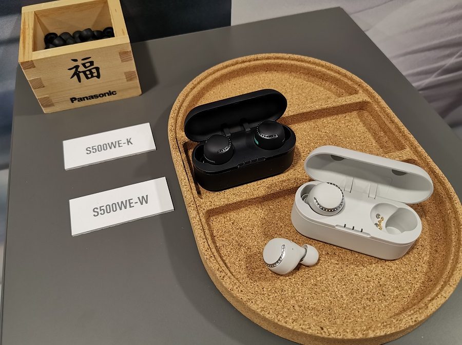 Dos pares de auriculares Panasonic S500W, unos negros y otros grises, sobre una bandeja de corcho