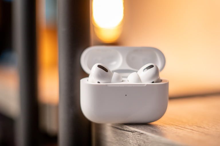 AirPods con su estuche de carga en una mesa lateral