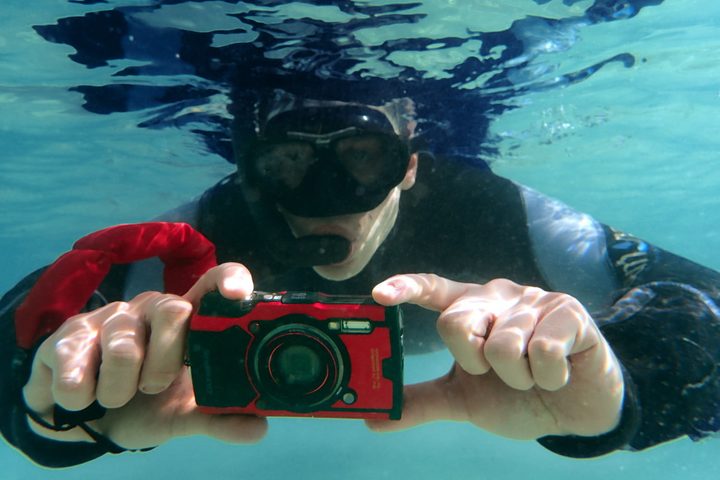 un chico tomando foto con una cámara debajo del agua