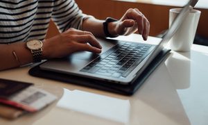 Persona usando su computadora portátil sobre una mesa