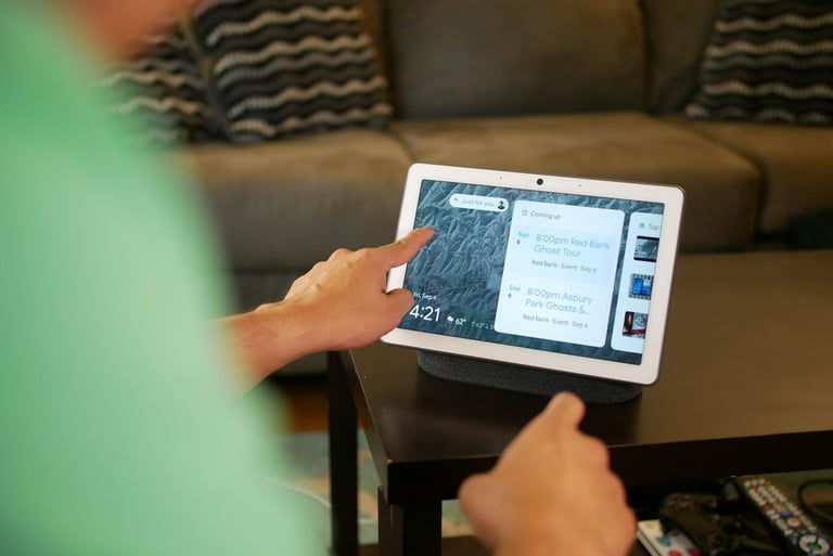 Una persona manipula un Google Nest Hub, uno de los mejores centros de control para el hogar inteligente