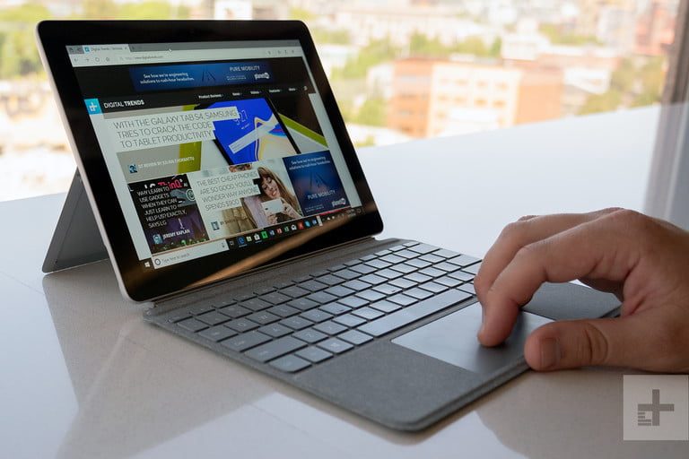 La mano de una persona usando la Microsoft Surface Go que está en modo laptop, una de las mejores laptops baratas