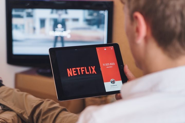 Una persona sostiene una tableta con el logo de Netflix
