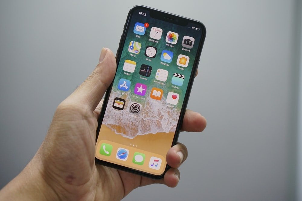 Una persona sostiene en sus manos un iPhone X para aprender cosas que hacer con un iPhone