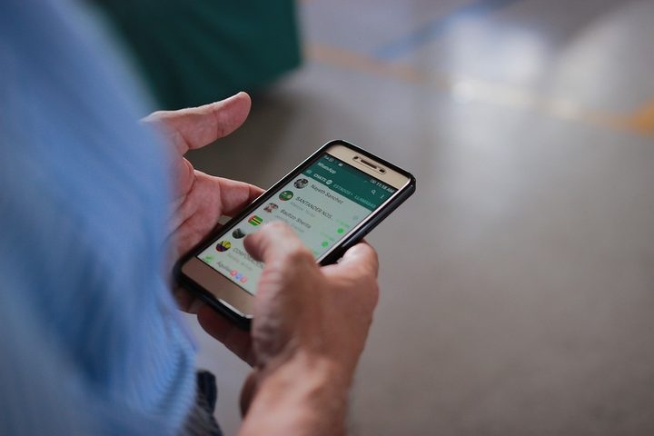 Una persona sostiene un teléfono celular con la aplicación de Whatsapp
