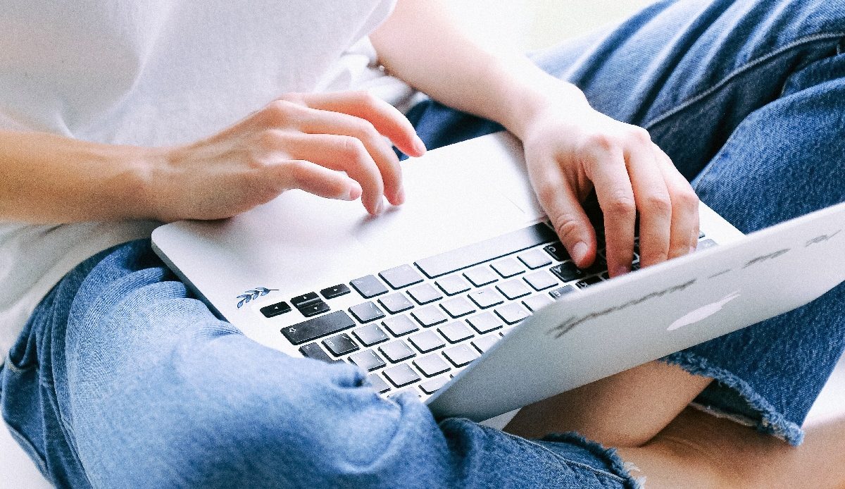 Una persona con su MacBook en las piernas para aprender a usar Control Center en macOS Big Sur