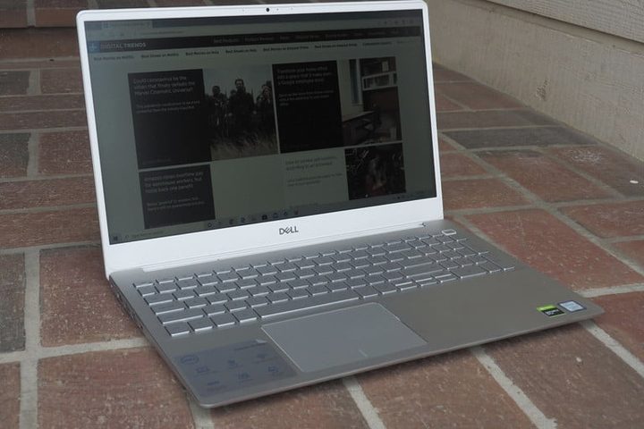 Dell Inspiron 15 7000 abierta sobre piso de ladrillos rojos