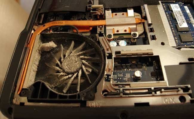 Interior de una computadora de escritorio mostrando un abanico lleno de polvo