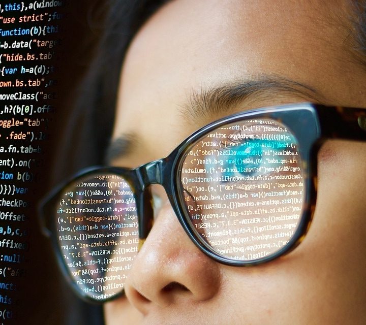Una mujer con anteojos revisa códigos de programación
