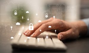 Una mano sobre un teclado para aprender a cómo quitar el password en Windows 10