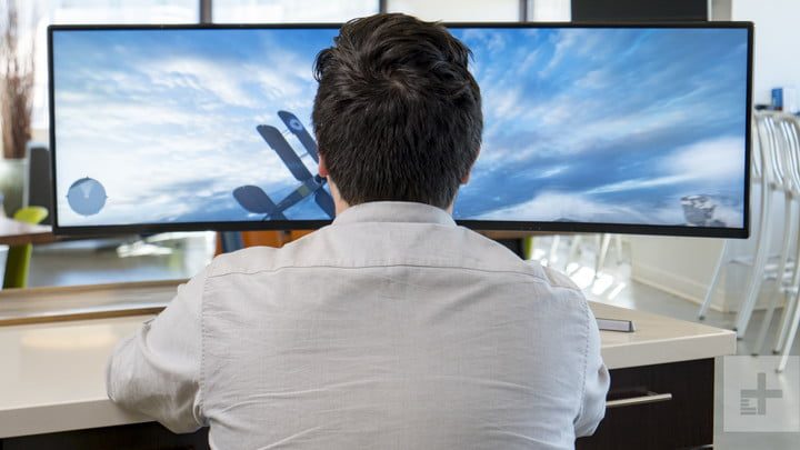 Hombre jugando con un monitor ultra ancho Samsung CHG90, uno de los mejores monitores 144Hz