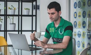 hombre tomando café y mirando su laptop – servicios gratuitos