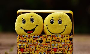 Una caja forrada con emojis con dos peluches de emojis