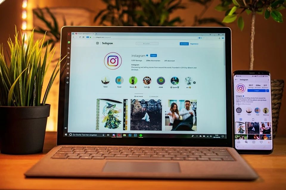 Una laptop y un teléfono con la aplicación de Instagram abierta