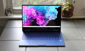 Galaxy Book Flex sobre una superficie, frente a una ventana y una planta a un lado