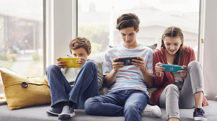 Una familia jugando sentados para comparar Nintendo Switch vs. Lite