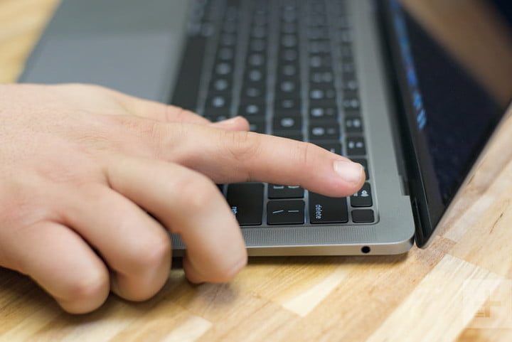 Una persona a punto de presionar el botón de encendido de una laptop para revisar una MacBook Air: problemas y sus soluciones