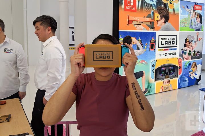 Una persona usando Nintendo Switch con RA y dos personas al fondo en una tienda