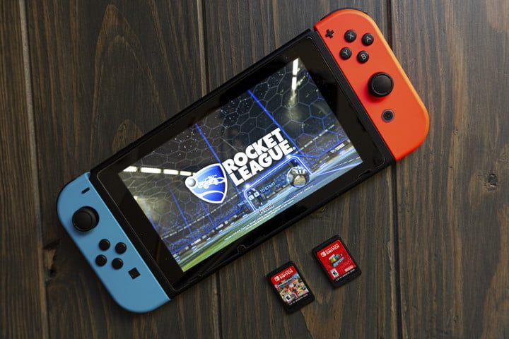 Nintendo Switch mostrando un juego en pantalla y dos cartuchos a un lado