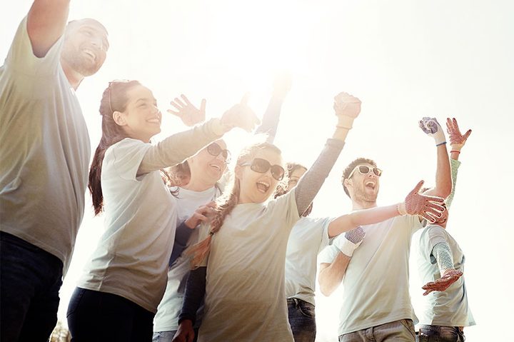 Jóvenes emocionados y alzando los brazos.