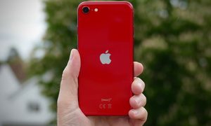 Una persona sostiene un Un teléfono iPhone SE 2020 de color rojo