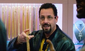 adan sandler usando lentes para ver y sosteniendo algo en sus manos