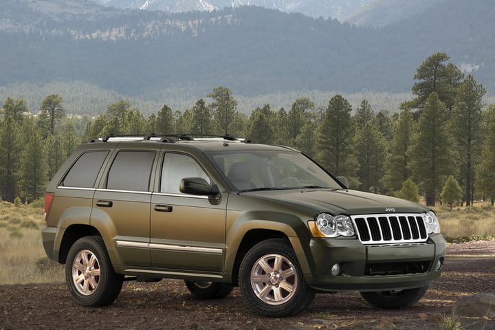 210 jeep gran cherokee de color verde aparcado en el campo